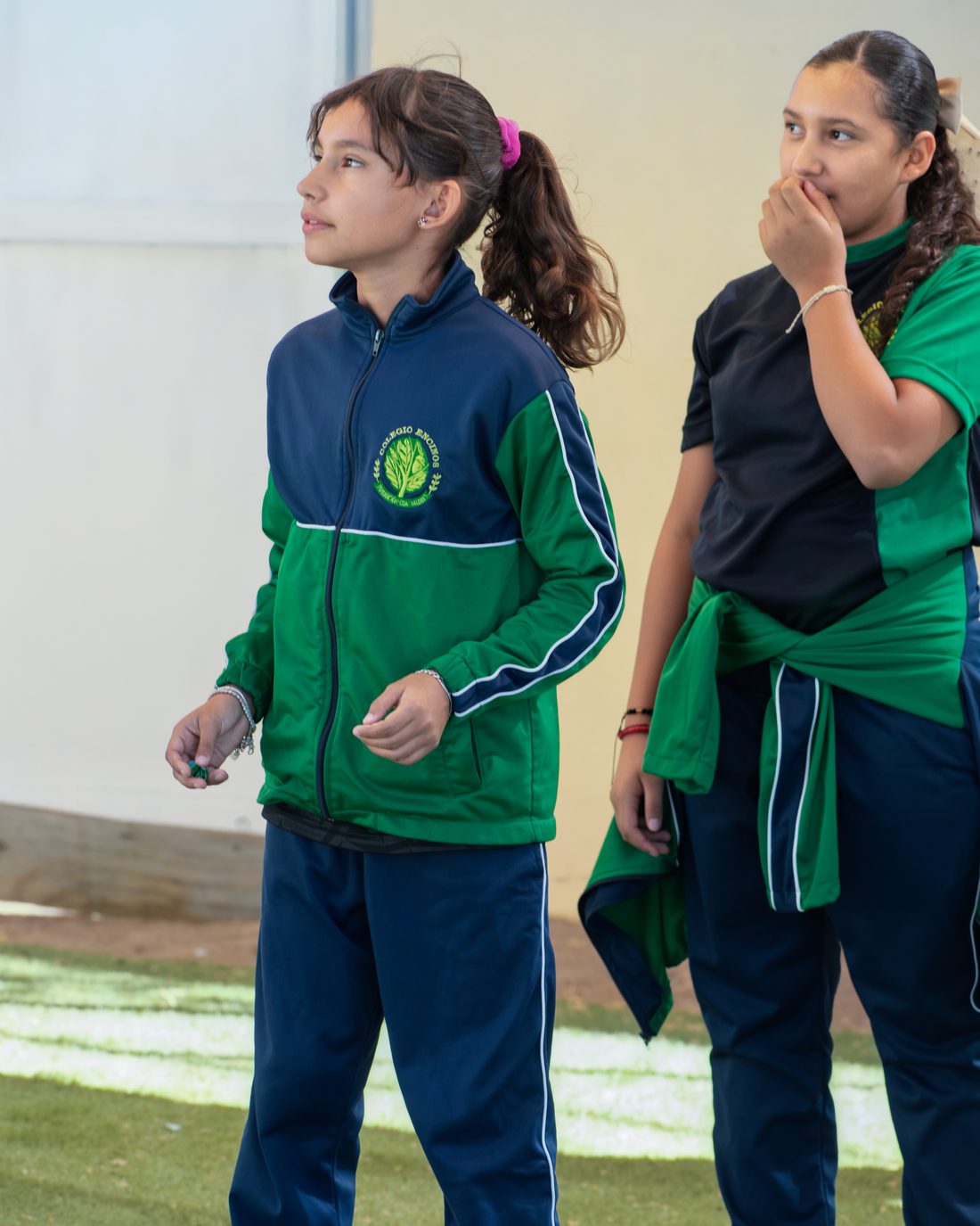 Dos alumnas de primaria exponiendo frente al grupo en el patio techado del colegio