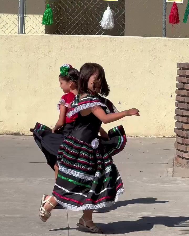 Two students dancing regional Mexican music in the playground