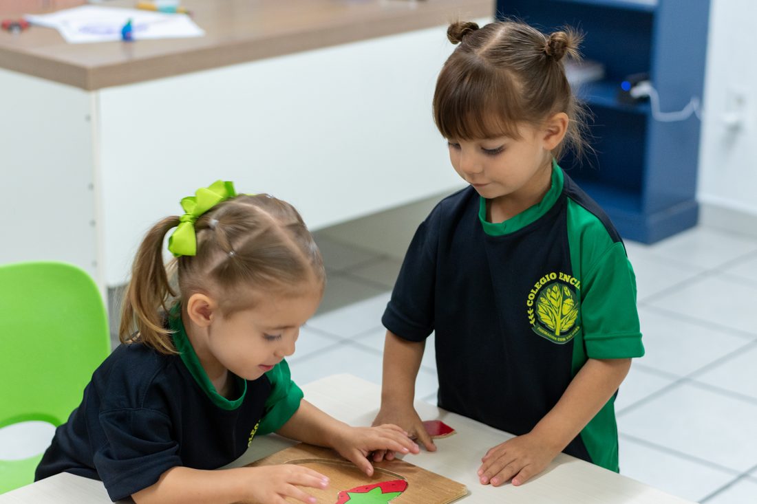 Dos niñas de preescolar de Colegio Encinos trabajando juntas con material didáctico de colores