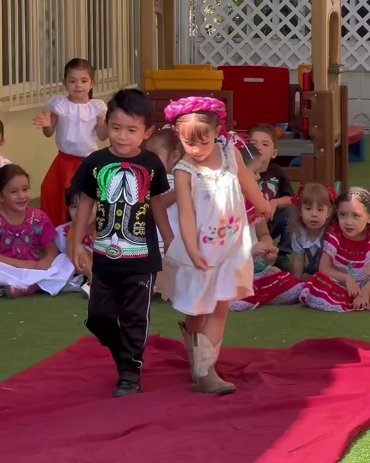 Alumnos caminando sobre una alfombra roja en la pasarela de trajes típicos