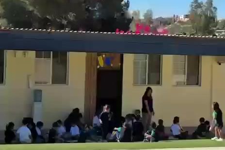 Patio de Colegio Encinos con techumbres, árboles y los cerros de Tecate al fondo